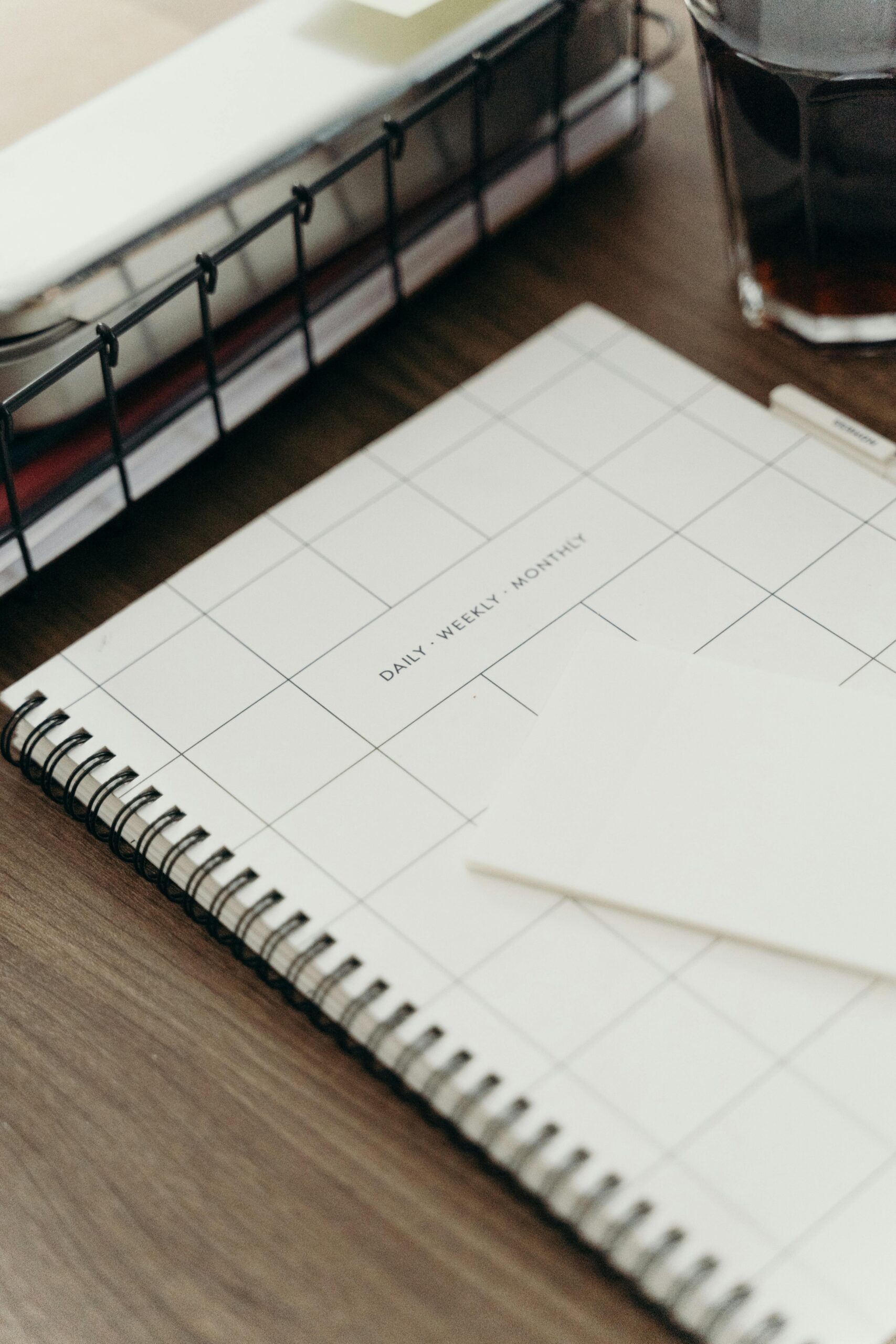 A minimalist desk setup featuring a planner, coffee, and tablet for productivity inspiration.